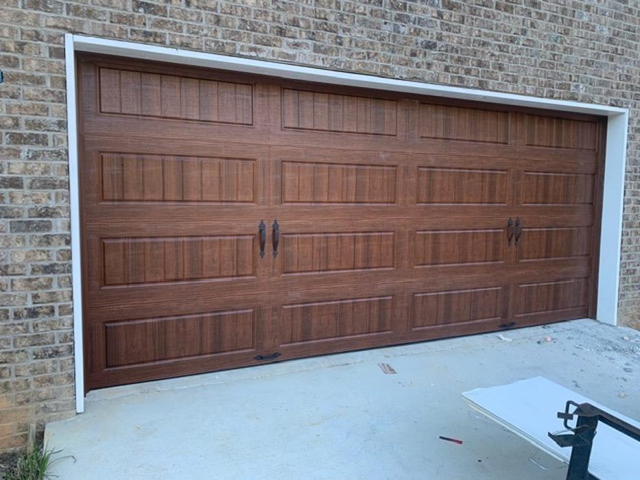 Rich dark wood-grain single garage door installation on a home in Atlanta, GA — Hawk Garage Doors