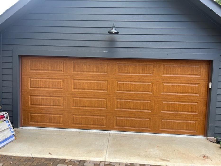 Warm wood-grain finish garage door installation on a residential home in the Atlanta metro area — Hawk Garage Doors