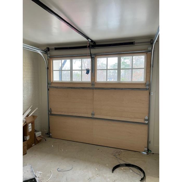Interior view of a natural wood carriage-style garage door with windows — Hawk Garage Doors