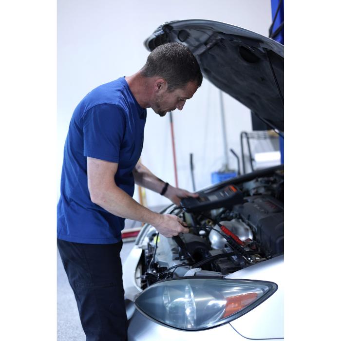 Auto mechanic, Tony, working under the hood of a vehicle