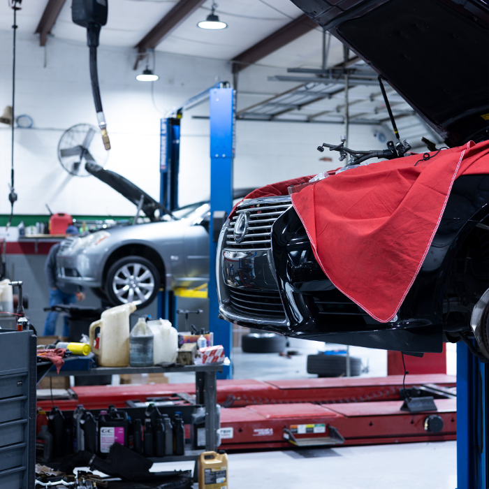 Two vehicles on lifts inside the Japanese Auto Repair shop