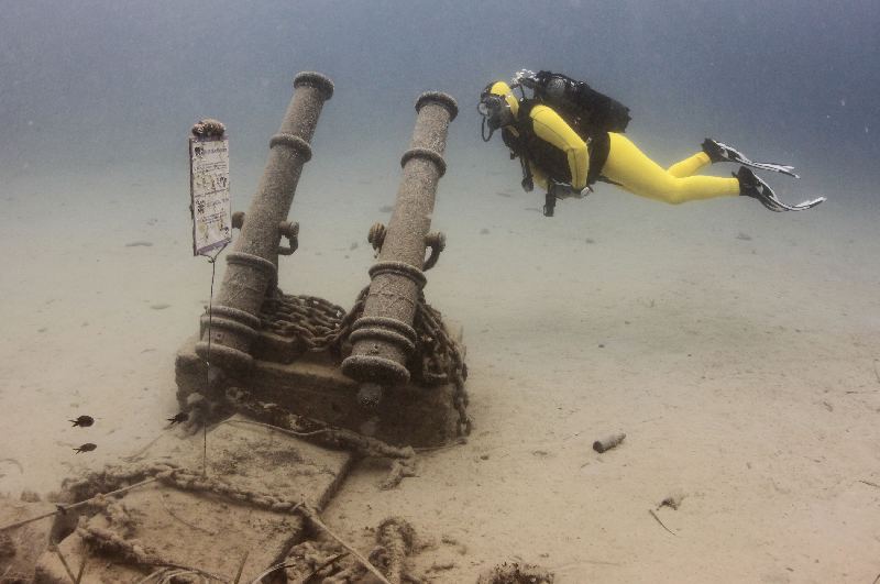 Diver swims next to a replica of the Venetian war cannon from the 17th-18th century in Historical Underwater Park in Mali Losinj
