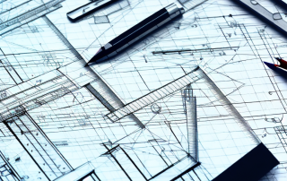 A drafting table with a detailed architectural blueprint