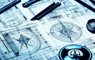 Various architectural symbols and blueprints spread out on a drafting table