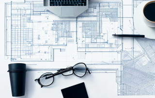 architektonischer grundriss auf schreibtisch mit zeichenwerkzeugen und kaffeetasse