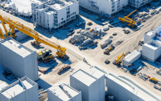 Luftaufnahme gut organisierte Baustelle mit Baumaschinen und urbaner Entwicklung im Hintergrund