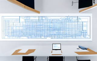 stadtplanungs-besprechungsraum mit blueprints und modellbauten auf dem tisch, natuerliches licht durch grosse fenster, strategische planungsatmosphaere