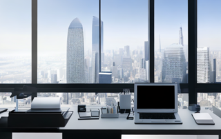 Professionelles Buero mit Laptop, Stift und Notizblock vor urbaner Kulisse.