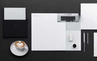 Ordentlicher Arbeitsplatz mit Laptop, Notizbuch und Kaffeetasse fuer professionelle Vorbereitung von Gehaltsvorstellungen.