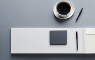 Professioneller Schreibtisch mit Laptop, Notizbuch, Stift und Kaffeetasse zeigt Vorbereitung und Strategien fuer Bewerbungen.