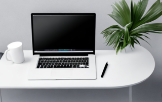 Buerotisch mit Laptop, Notizblock, Stift und Kaffeetasse in professioneller Umgebung fuer produktives Arbeiten.