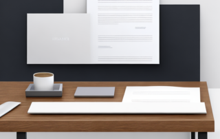 Moderner bueroarbeitsplatz mit laptop, dokumentenstapel und elegantem stift auf holzschreibtisch.