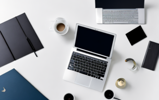 Ordentliches Arbeitsplatz mit Laptop, Notizblock und Stift, betont praezises und klares Arbeitsumfeld.