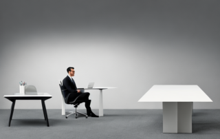 Business Professional am Tisch in minimalistischem Buero, bereit fuer strategische Verhandlungen.