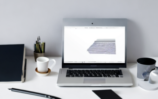 Schreibtisch Setup mit Laptop, Notizbuch, Stift und Tasse Kaffee; professioneller Arbeitsplatz fuer Bewerbungsschreiben.