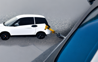 Nahaufnahme Autowindschutzscheibe mit sichtbarem Steinschlag, Hand haelt Reparaturwerkzeug fuer professionelle Reparaturdienstleistungen