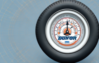 A dunlop tire with a pressure gauge inserted into it
