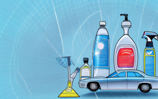 Various types of glass cleaners next to a sparkling clean car windshield