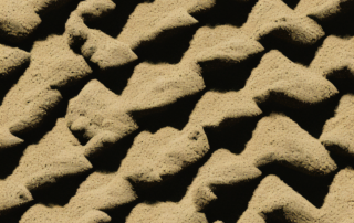 Several bags of different types of autoflowering soil stacked on a shelf in a hardware store setting