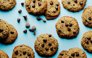 A variety of delicious hemp cookies laid out on a dog bowl with a happy dog eagerly waiting to eat them