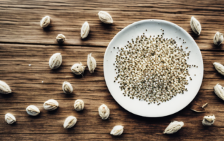A handful of peeled organic hemp seeds scattered on a rustic wooden table