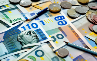 A home safe overflowing with various denominations of euro bills and coins