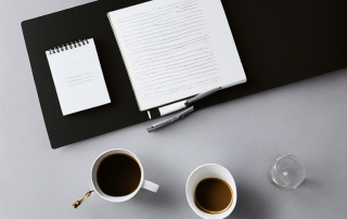 Organisiertes Buero mit Laptop, Notizblock und Kaffee fuer produktives Arbeiten.