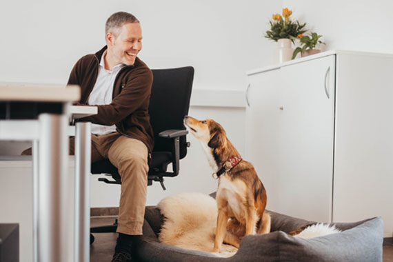 Mann im Büro mit Hund an seiner Seite